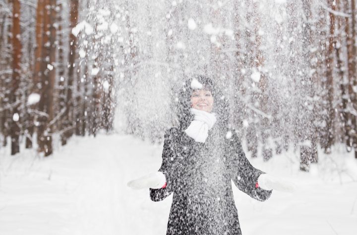 Happy young woman having fun in the snow