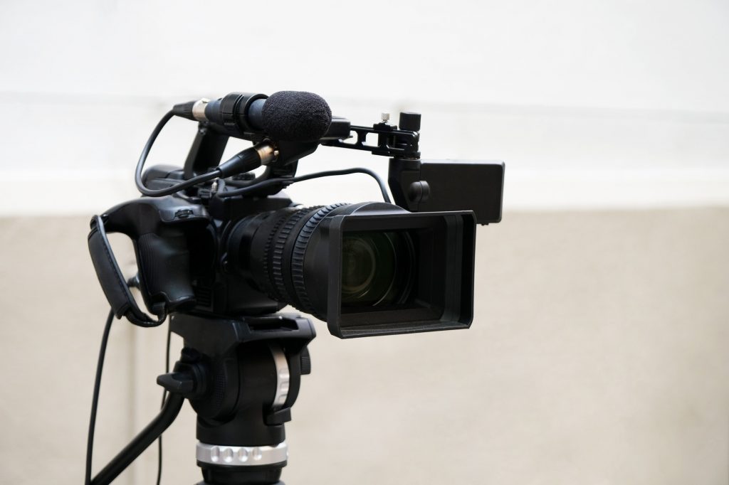 professional digital video or movie camera with microphone on tripod