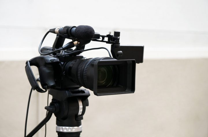 professional digital video or movie camera with microphone on tripod