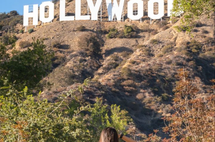 Attractive young woman looking at Hollywood sign, Los Angeles, California
