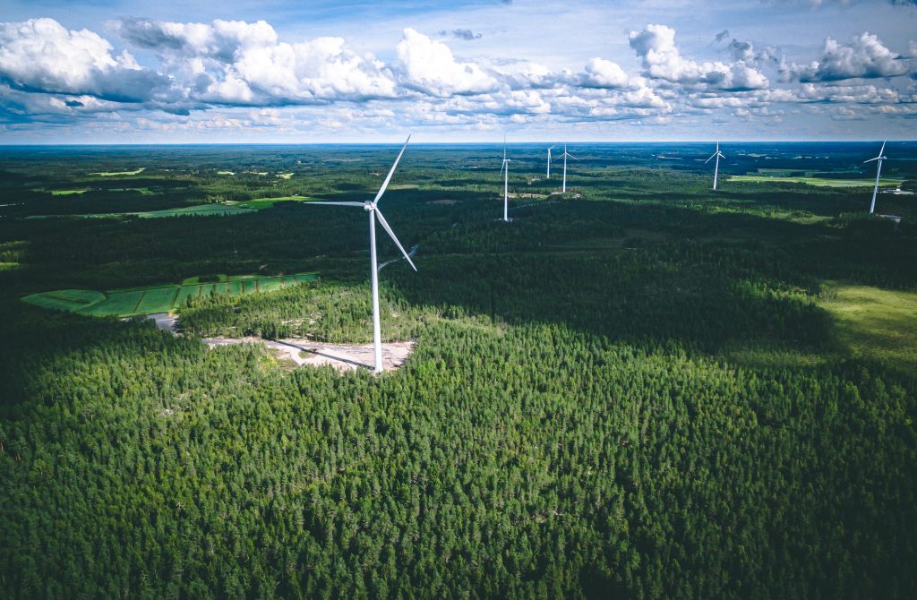 Windmills. Aerial view of windmills in green summer forest in Finland.