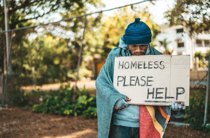 Beggars stand on the street with homeless messages please help.