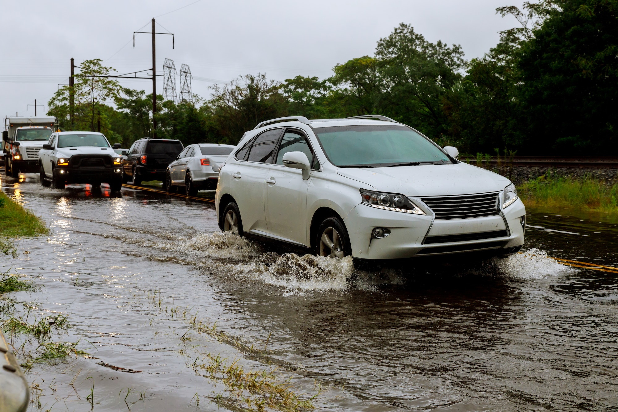 Cars driving on a flooded road during a by heavy rain,