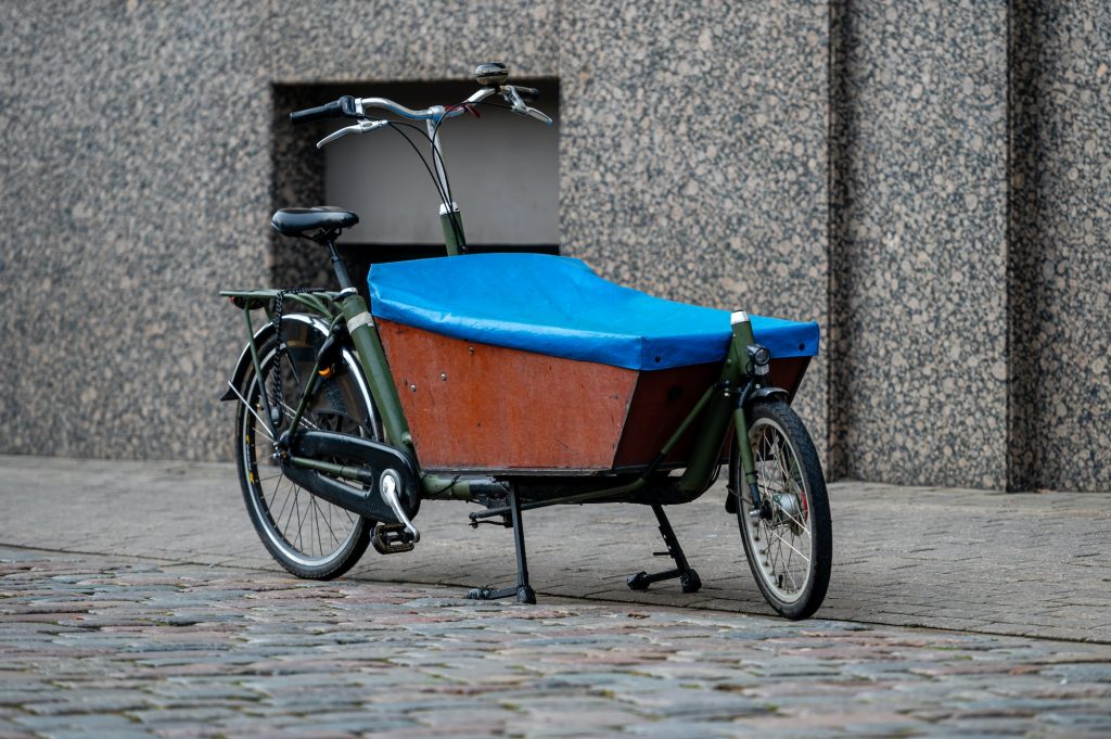 Cargo bicycle for fast city delivery parked in front of a house