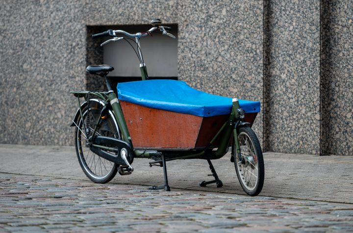 Cargo bicycle for fast city delivery parked in front of a house