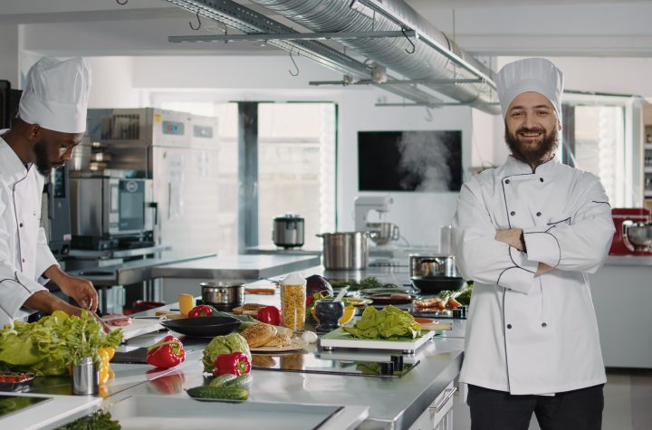 Portrait of male cook sitting in professional gastronomy kitchen