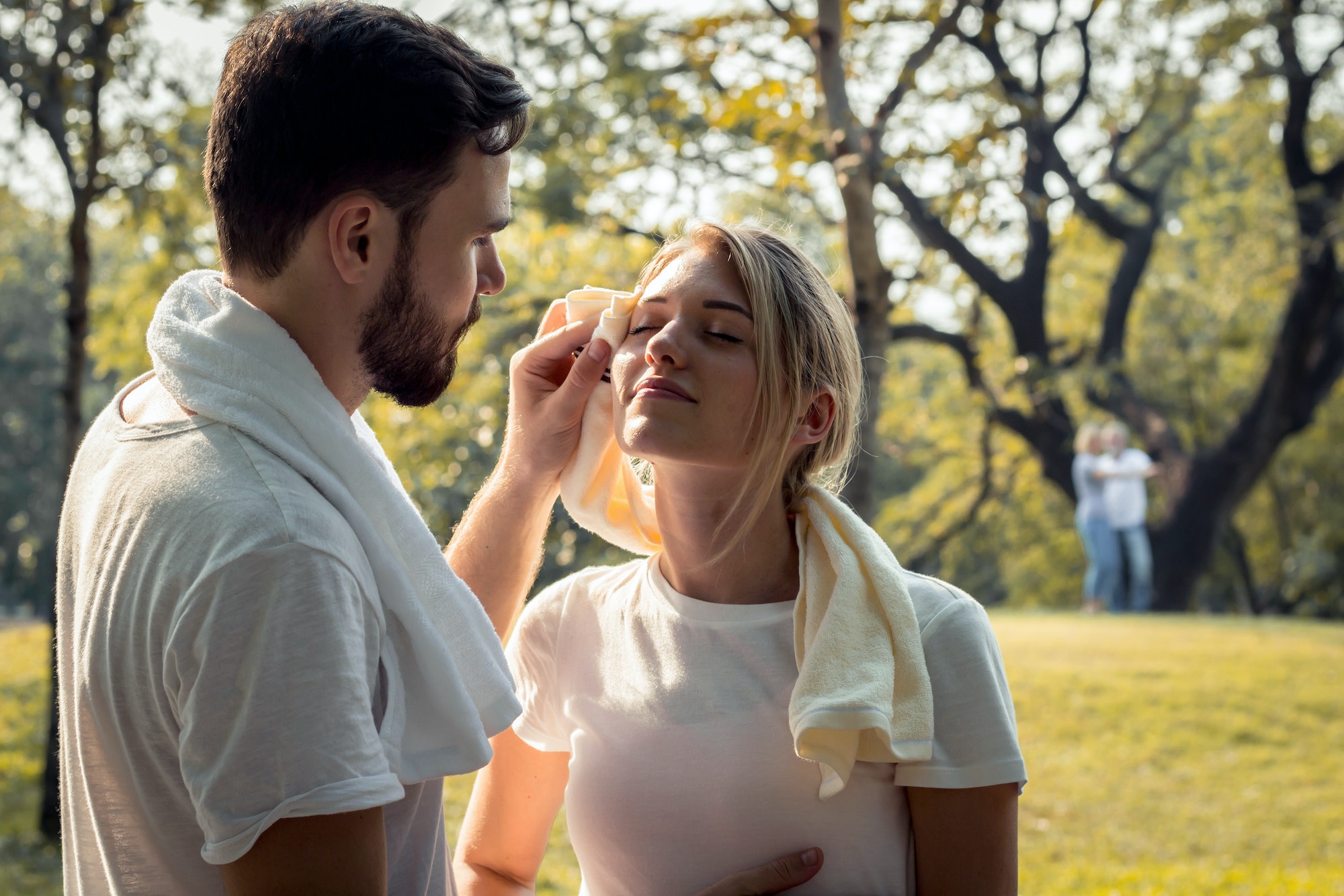 Young couples are wiping sweat after exercising.
