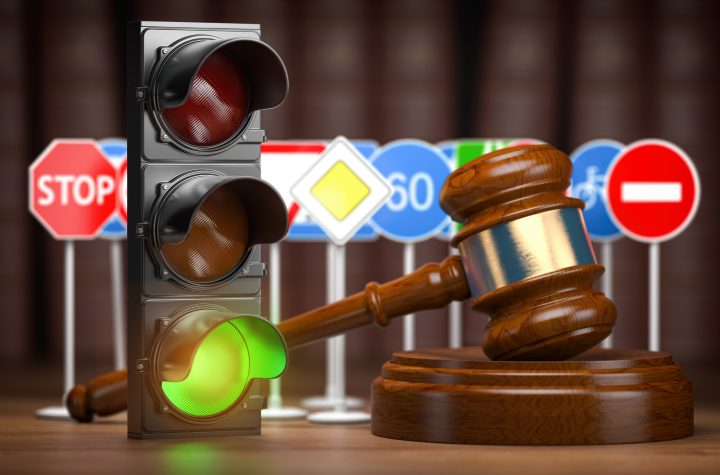 Traffic law concept. Judge gavel with traffic lights and traffic signs.