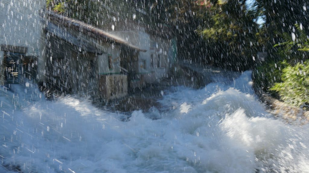 Flood of water, heavy rain, fast stream of water in a village