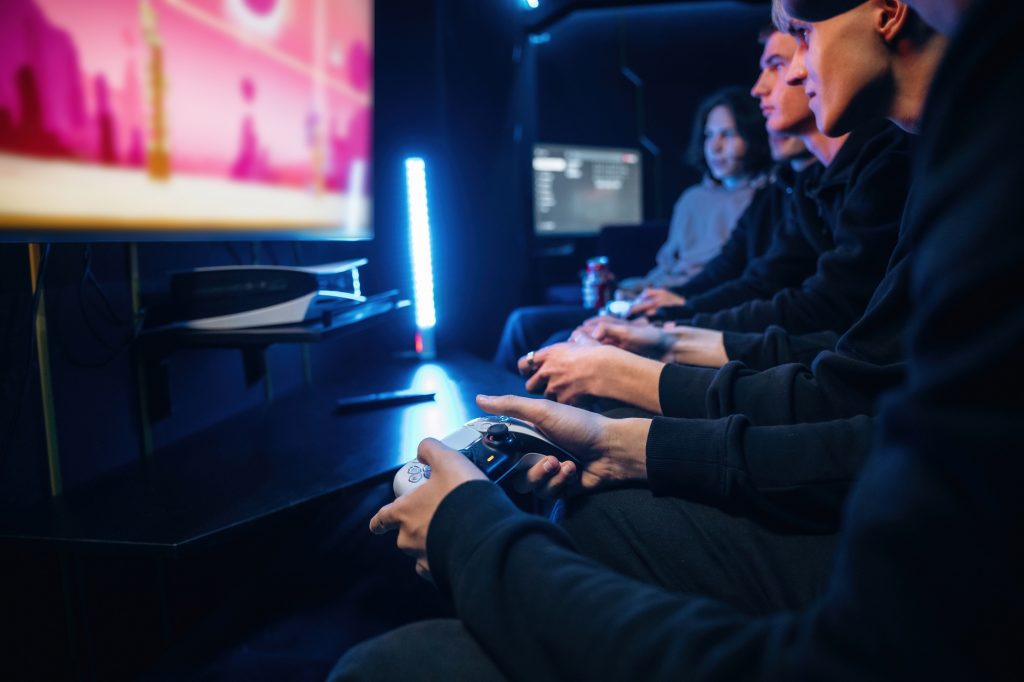 Young gamers are with console controllers indoors