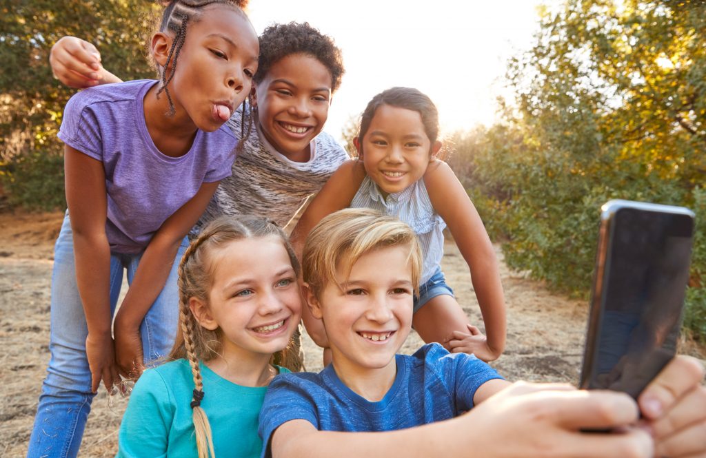 Group Of Multi-Cultural Children Posing For Selfie With Friends In Countryside Together
