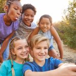 Group Of Multi-Cultural Children Posing For Selfie With Friends In Countryside Together