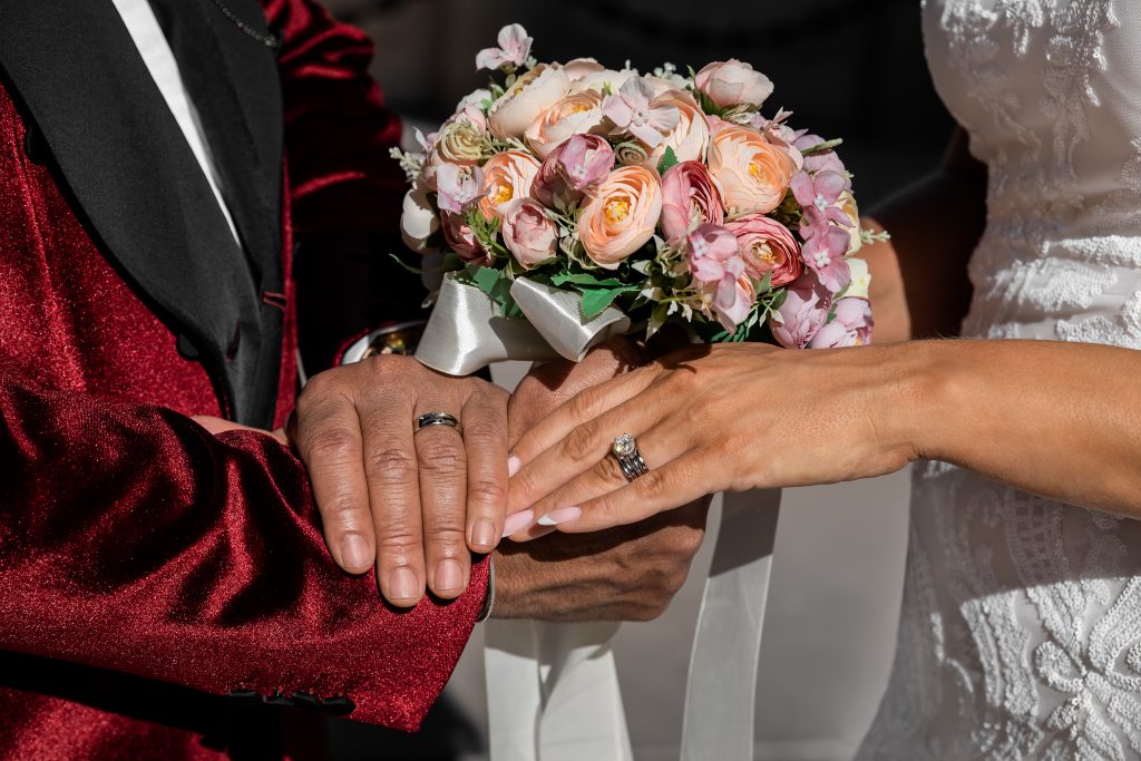 Closeup of bride and groom holding hands and showing rings on Wedding day, special occasion - Image
