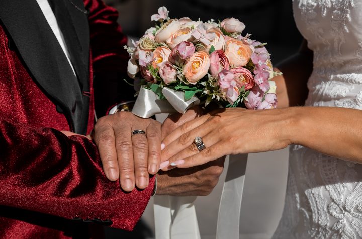Closeup of bride and groom holding hands and showing rings on Wedding day, special occasion - Image