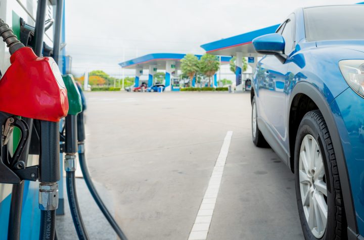 Blue luxury SUV car fueling at gas station. Refuel fill up with petrol gasoline. Petrol pump filling fuel nozzle in gas station. Petrol industry. Petrol price and oil crisis concept. Energy crisis. Tankstelle