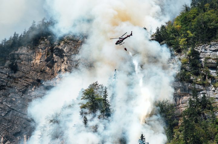 helicopter extinguishes forest fire on the slope of a fuming mountain, Löschhubschrauber