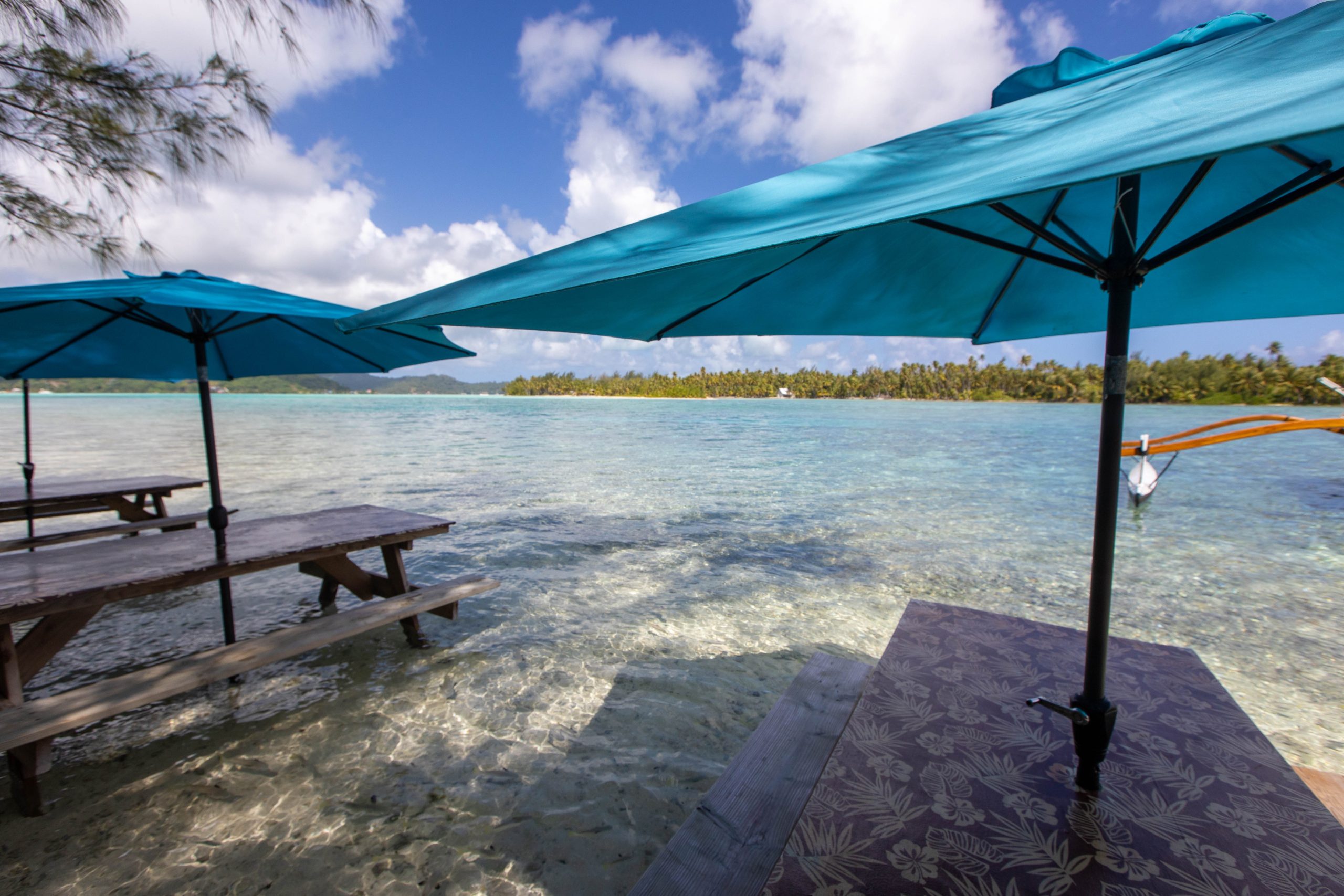 picnic-tables-in-tropical-island-ocean-water-on-a-2026-09-23-00-40-05-utc, tropischer Strand